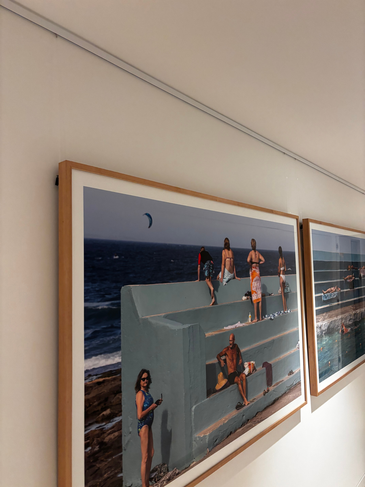 Finished gallery wall hung on a white picture rail system with two framed beach photographs