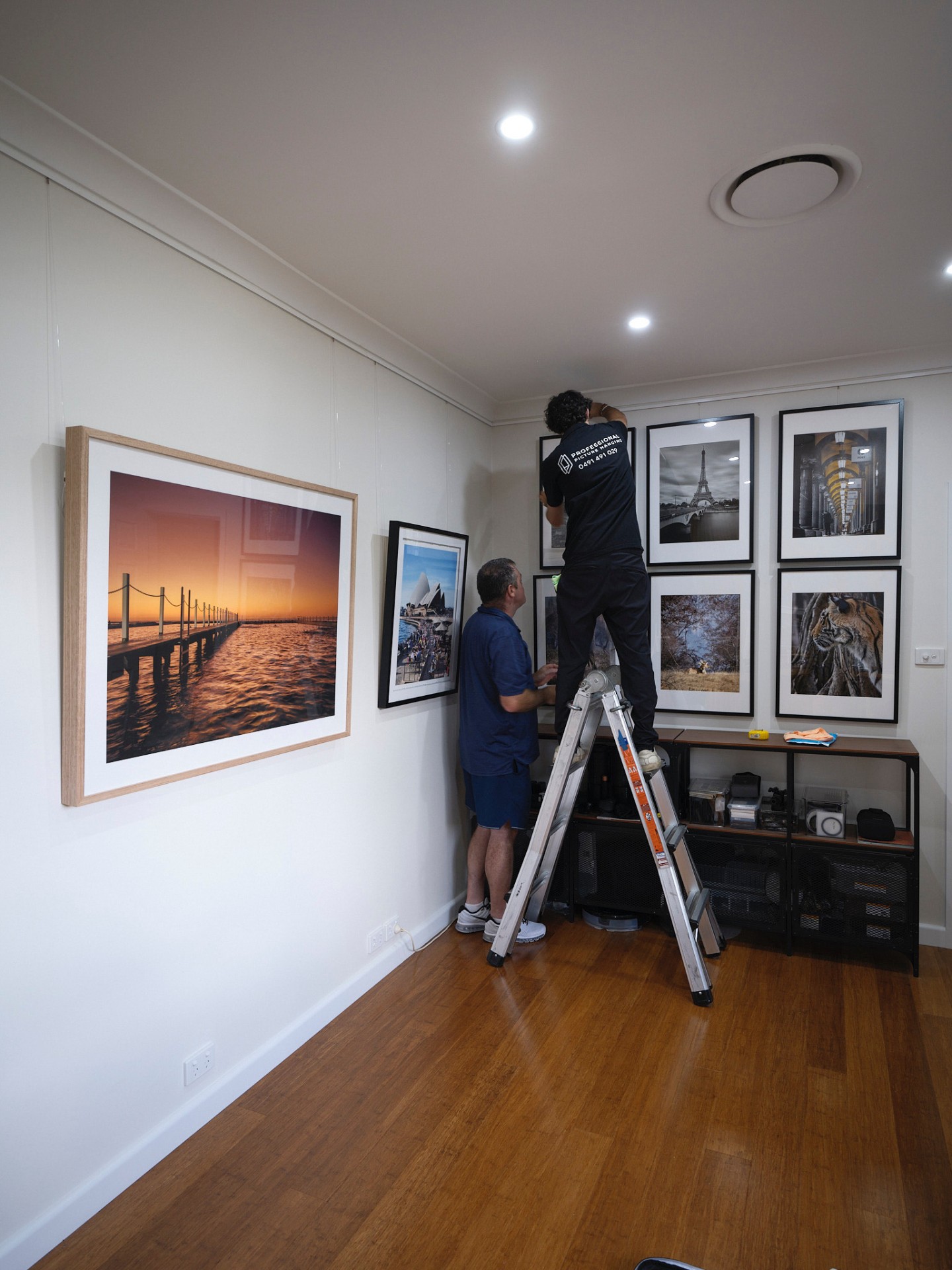 Gallery wall of framed photography on rail system